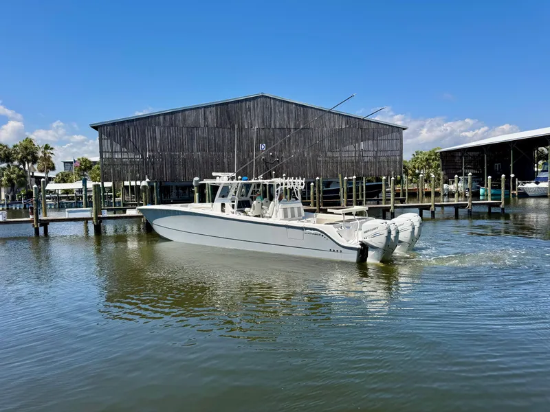 Slide: The Image of 2022 Invincible 46 Catamaran cruising near a marina under a clear blue sky. - 17