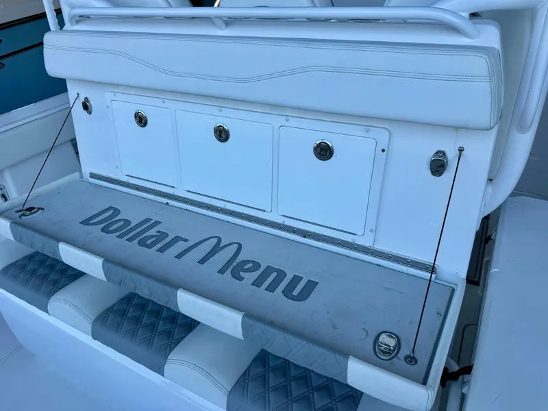 Slide: The Image of Invincible 46 Catamaran 2022, white seating area with "Dollar Menu" text on cushion. - 31