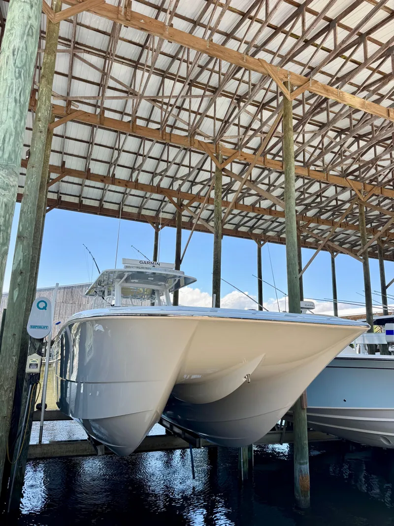 Slide: The Image of 2022 Invincible 46 Catamaran docked under a wooden shelter. - 35