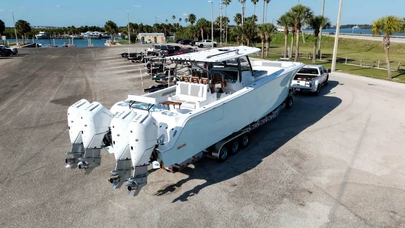 Slide: The Image of 2026 Front Runner 43 Catamaran on trailer, parked near waterfront with palm trees. - 42