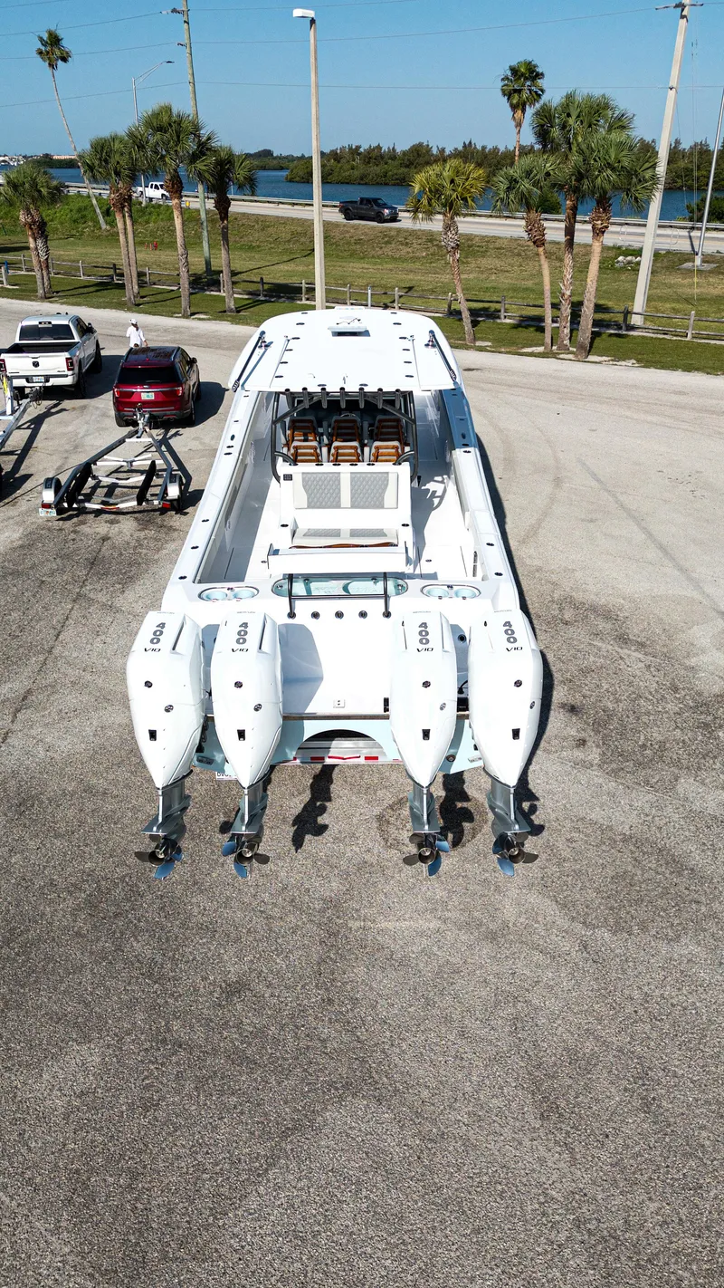 Slide: The Image of 2026 Front Runner 43 Catamaran with quad engines on a trailer, parked near palm trees. - 43