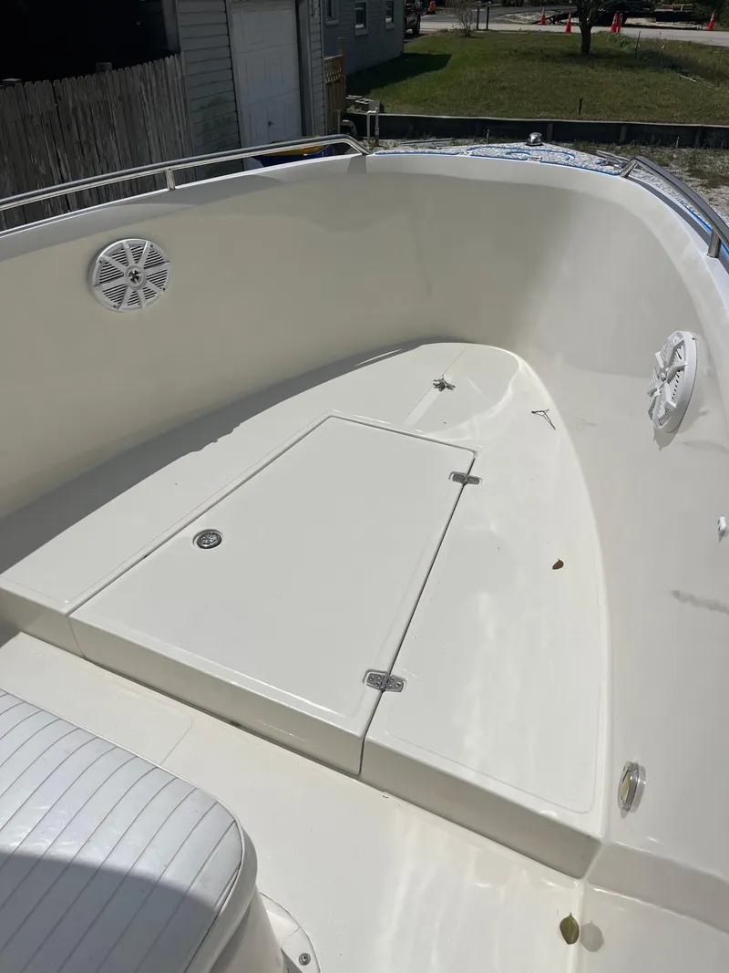 Slide: The Image of 1998 Blue Fin 25 Center Console boat deck, featuring storage hatch and speakers. - 11