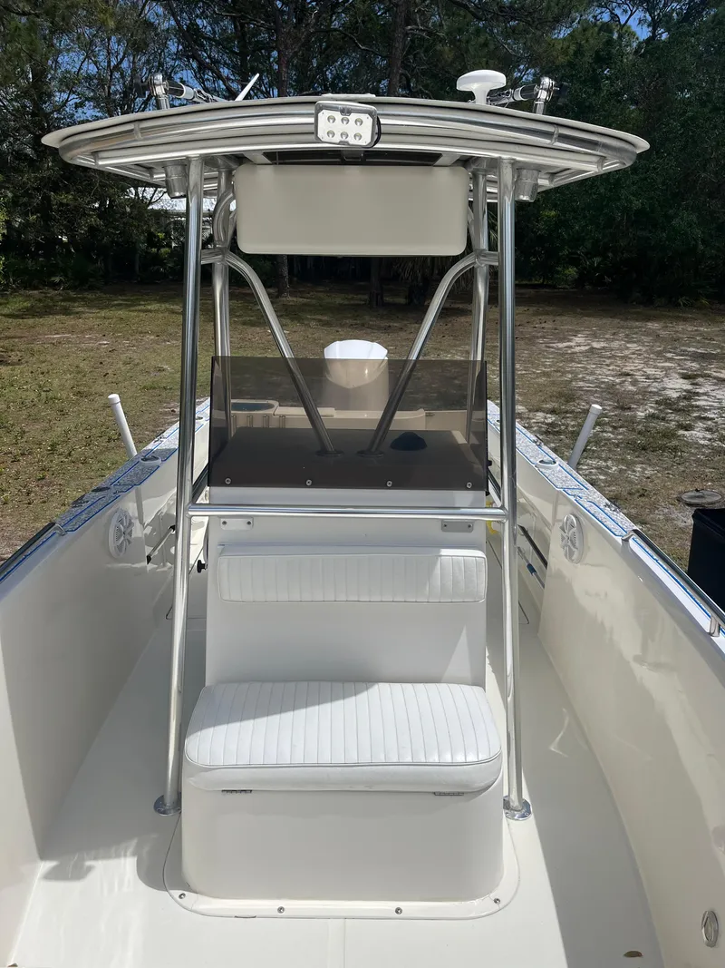 Slide: The Image of 1998 Blue Fin 25 Center Console boat with T-top and seating, parked outdoors. - 12
