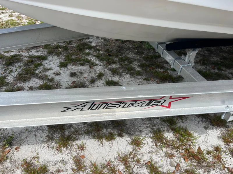 Slide: The Image of Trailer for 1998 Blue Fin 25 Center Console boat on sandy ground. - 13