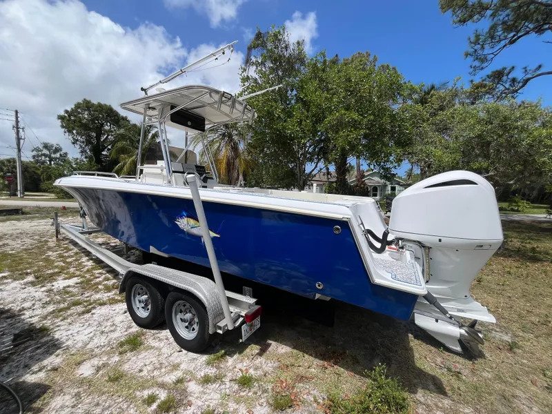 Slide: The Image of 1998 Blue Fin 25 Center Console boat on trailer, parked outdoors. - 2
