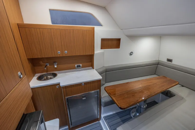 Slide: The Image of Luxurious interior of 2026 Front Runner 47 Center Console with kitchenette and seating area. - 25