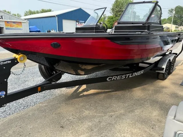 Slide: The Image of 2025 Crestliner 2050 Fish Hawk boat on trailer, red and black design, parked outdoors. - 9
