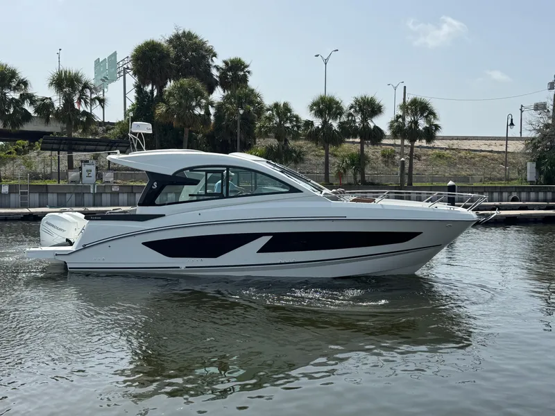 Slide: The Image of 2022 Beneteau Gran Turismo 32 yacht on calm water, with palm trees in the background. - 11