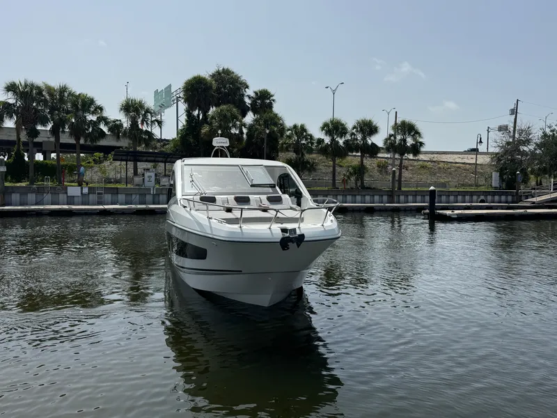 Slide: The Image of 2022 Beneteau Gran Turismo 32 yacht docked in a marina with palm trees. - 2