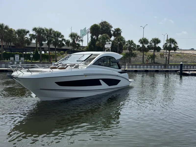 Slide: The Image of 2022 Beneteau Gran Turismo 32 yacht on calm water, surrounded by palm trees. - 4