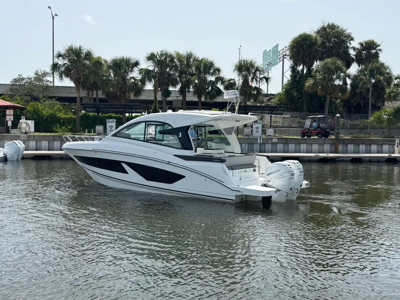 Slide: The Image of 2022 Beneteau Gran Turismo 32 yacht docked on a sunny day with palm trees in the background. - 5