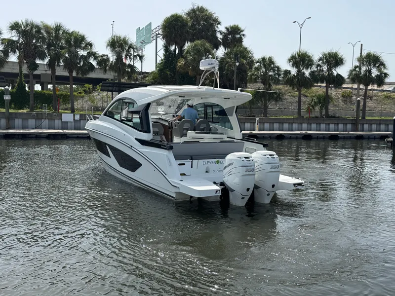 Slide: The Image of 2022 Beneteau Gran Turismo 32 yacht on water, surrounded by palm trees. - 6