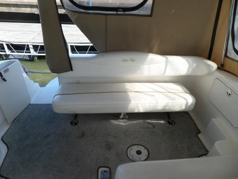 Slide: The Image of 2003 Sea Ray 280 Sundancer interior with cushioned seating and carpeted floor. - 12