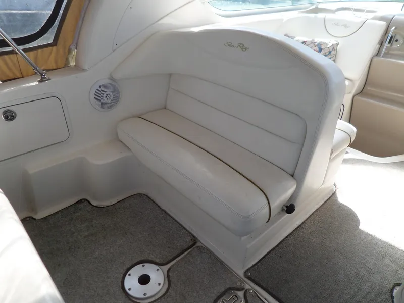 Slide: The Image of 2003 Sea Ray 280 Sundancer interior with white seating and carpeted flooring. - 15