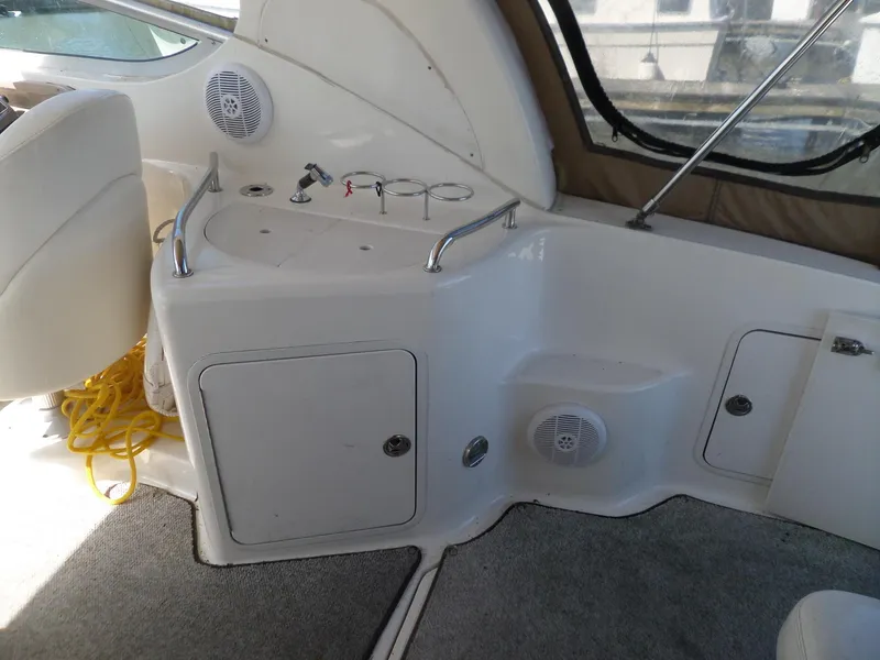 Slide: The Image of 2003 Sea Ray 280 Sundancer interior with sink, storage, and speakers. - 16