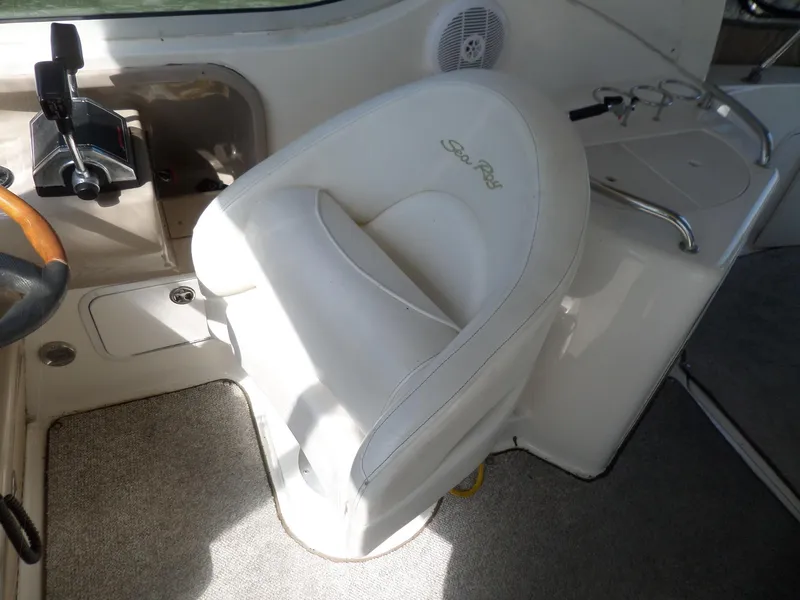 Slide: The Image of 2003 Sea Ray 280 Sundancer helm seat with control panel and cup holders. - 17