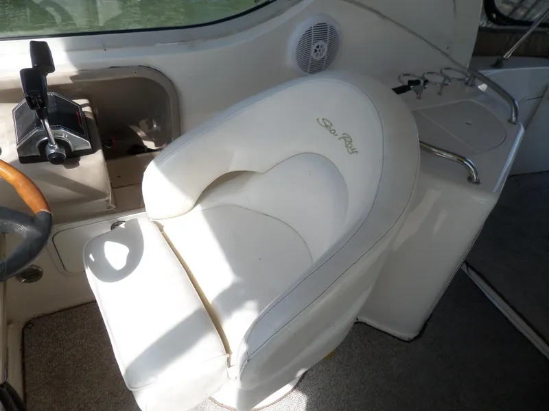 Slide: The Image of Captain's seat on 2003 Sea Ray 280 Sundancer boat, featuring white upholstery and control panel. - 18