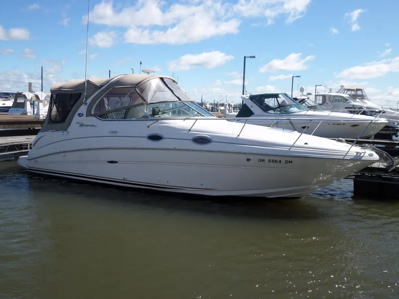 Slide: The Image of 2003 Sea Ray 280 Sundancer boat docked in marina under blue sky. - 2