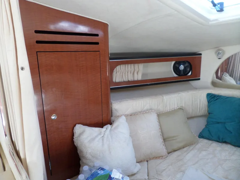 Slide: The Image of Interior cabin of 2003 Sea Ray 280 Sundancer with wood paneling and cushions. - 21
