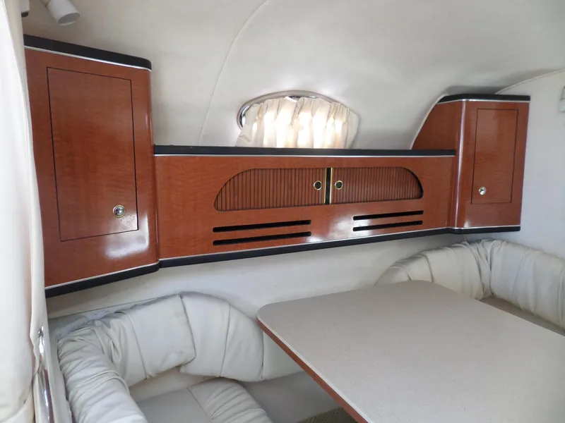 Slide: The Image of Interior of 2003 Sea Ray 280 Sundancer with wood cabinets and cushioned seating. - 25