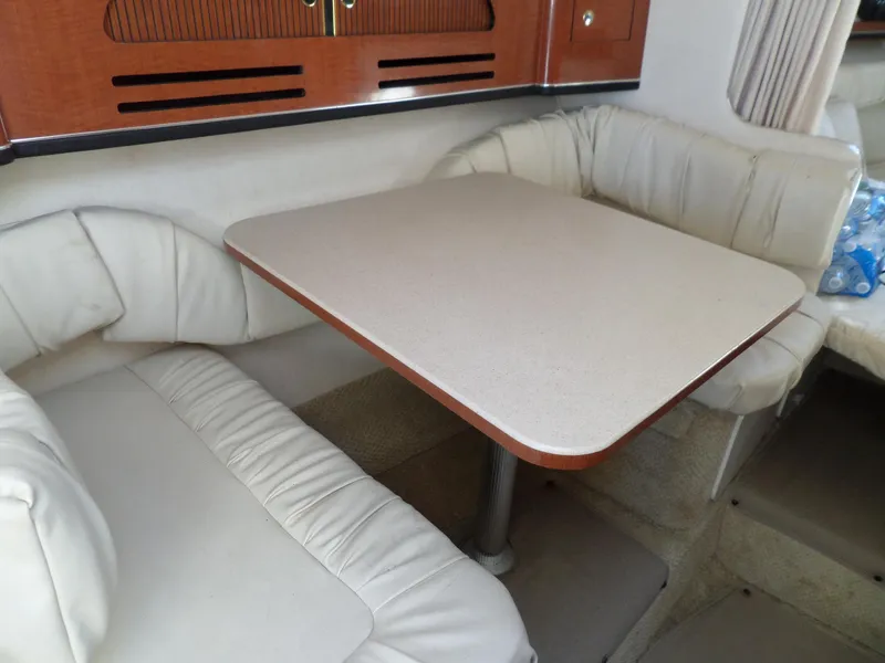 Slide: The Image of 2003 Sea Ray 280 Sundancer interior with beige seating and table. - 26