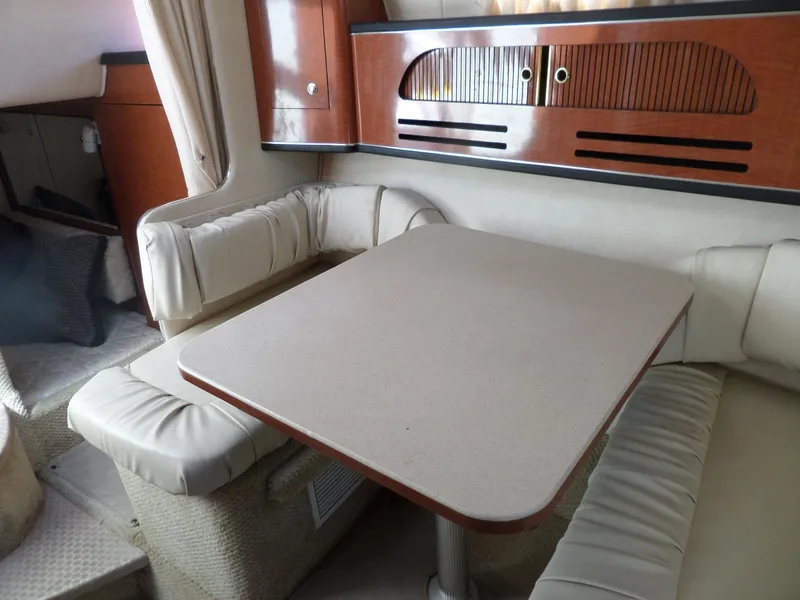 Slide: The Image of Interior of 2003 Sea Ray 280 Sundancer with dining area and cushioned seating. - 27