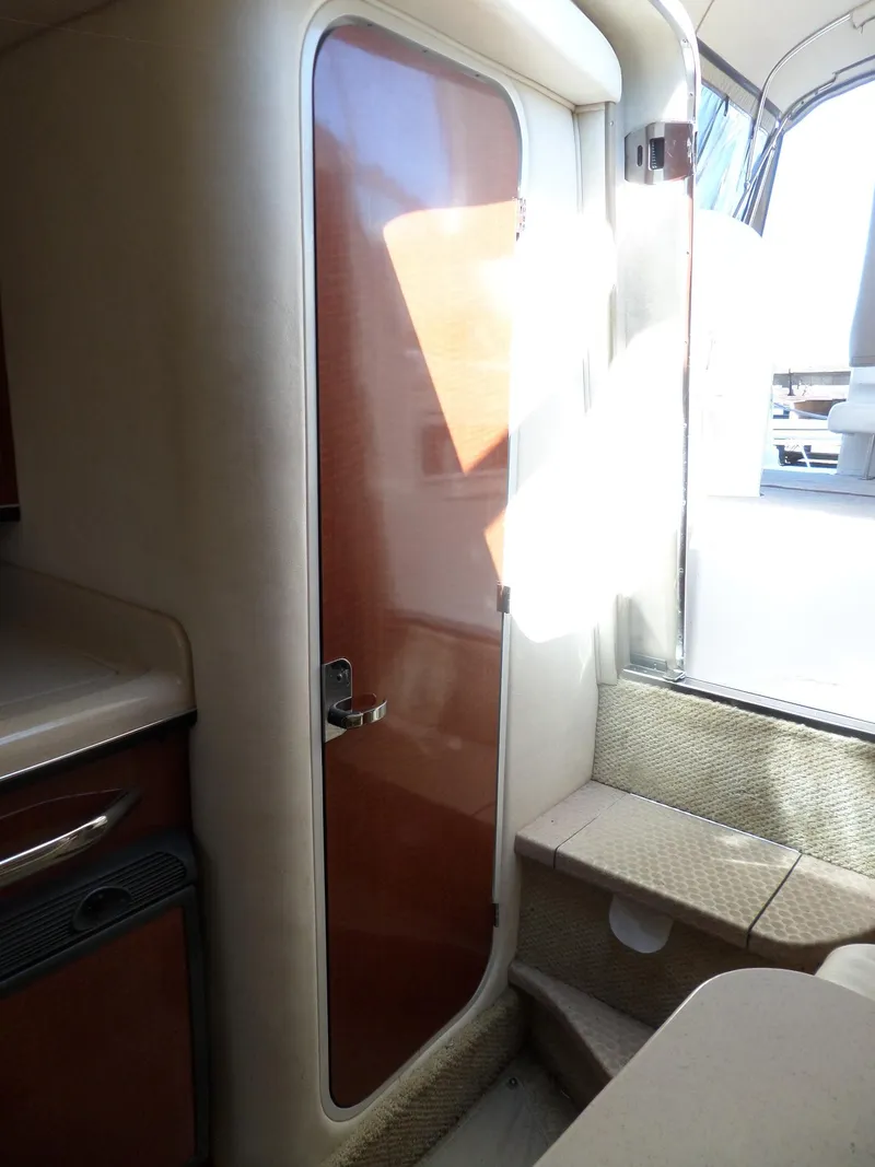 Slide: The Image of 2003 Sea Ray 280 Sundancer cabin interior with wooden door and steps. - 29