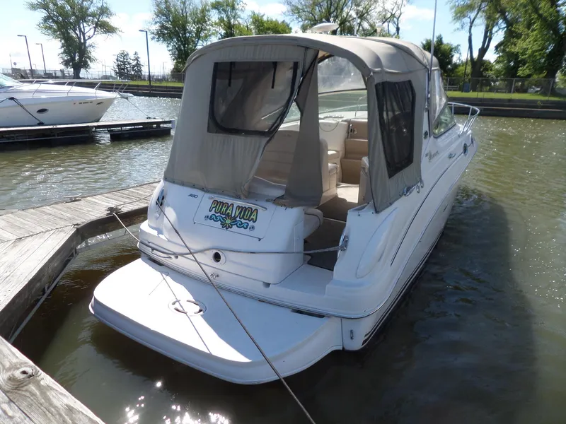 Slide: The Image of 2003 Sea Ray 280 Sundancer docked, rear view with canopy, in a marina setting. - 3