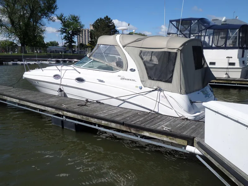 Slide: The Image of 2003 Sea Ray 280 Sundancer docked at marina, featuring beige canopy and sleek design. - 4