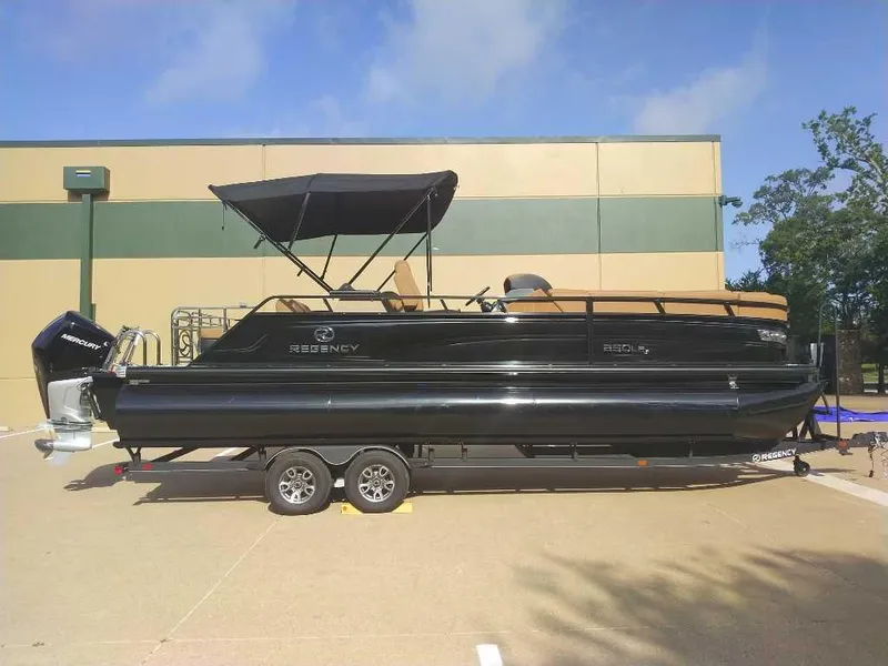 Slide: The Image of 2025 Regency 250 LE3 Sport pontoon boat on trailer, parked outdoors. - 2