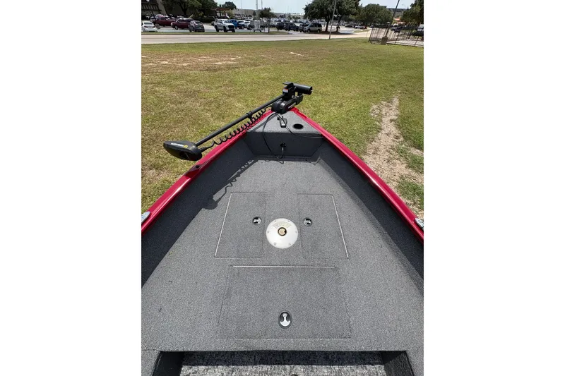 Slide: The Image of 2025 Tracker Super Guide V-16 T boat deck with trolling motor, parked on grass. - 40