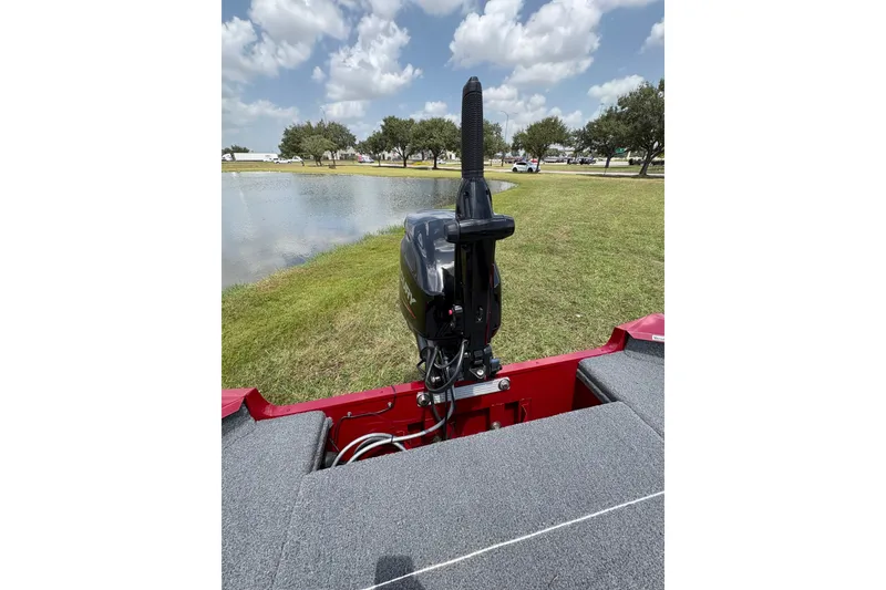 Slide: The Image of 2025 Tracker Super Guide V-16 T boat with motor by a lake under cloudy sky. - 46