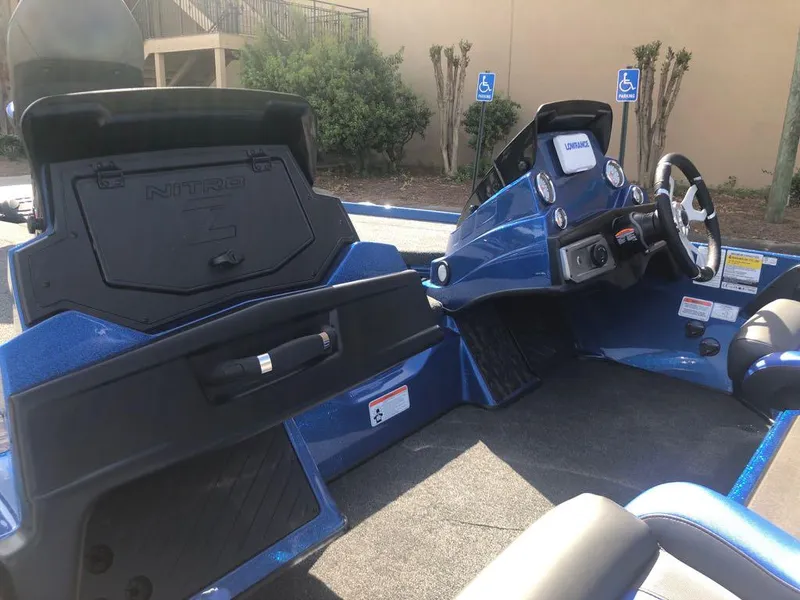Slide: The Image of 2025 Nitro Z20 XL boat interior with open storage compartments and steering console. - 11