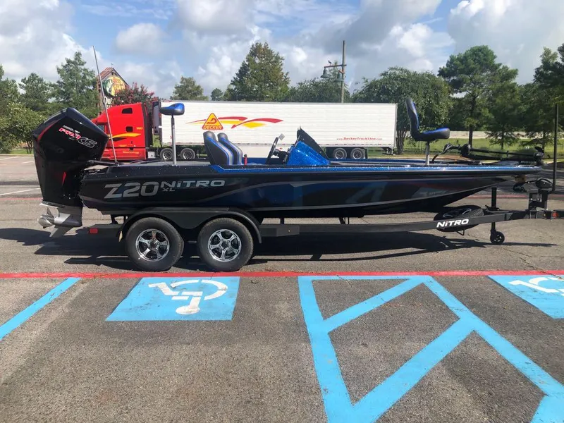Slide: The Image of 2025 Nitro Z20 XL boat on trailer in parking lot, clear sky background. - 5