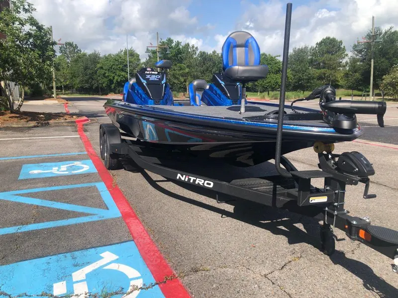Slide: The Image of 2025 Nitro Z20 XL boat parked in a lot, featuring blue seats and a sleek design. - 6