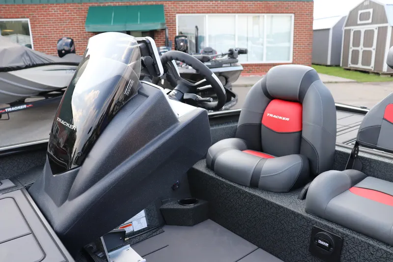 Slide: The Image of 2025 Tracker Savage 215 boat interior with steering console and cushioned seats. - 12