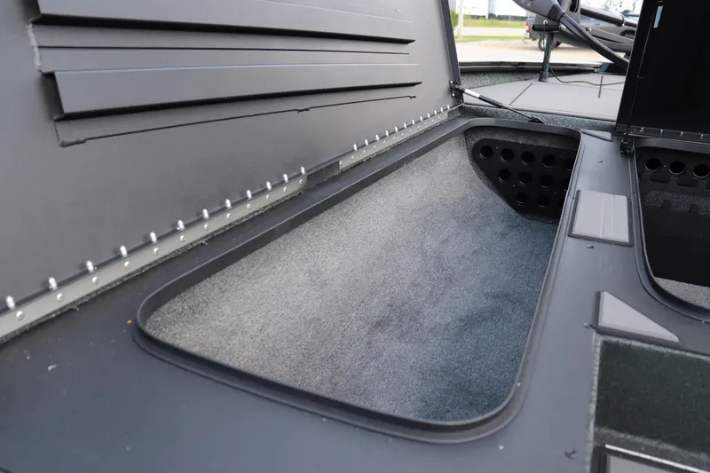 Slide: The Image of 2025 Tracker Savage 215 boat storage compartment with carpeted interior and organized layout. - 7