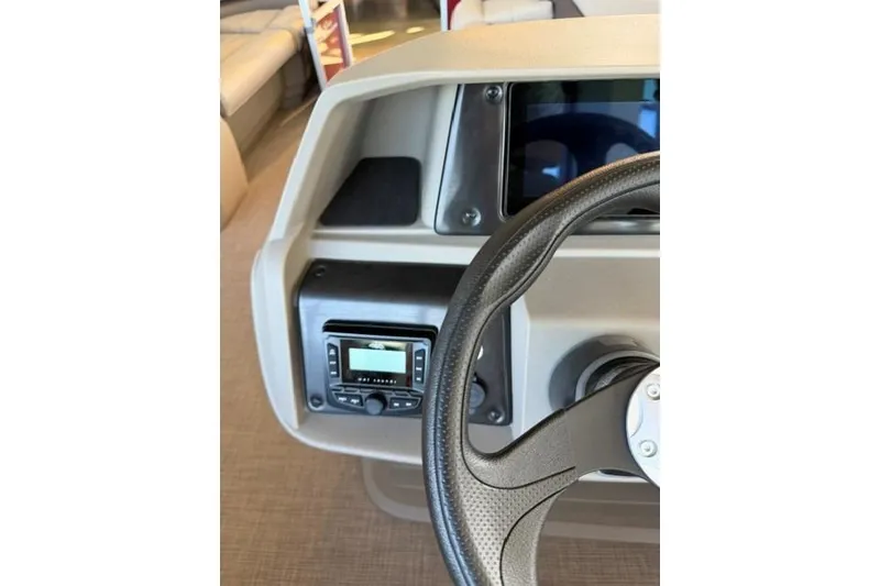 Slide: The Image of 2025 Sun Tracker Party Barge 18 DLX dashboard with steering wheel and control panel. - 12