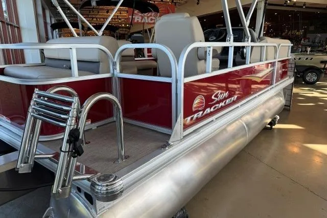 Slide: The Image of 2025 Sun Tracker Party Barge 18 DLX pontoon boat with red exterior and seating. - 2