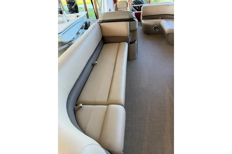 Slide: The Image of 2025 Sun Tracker Party Barge 18 DLX interior with beige seating and spacious layout. - 4