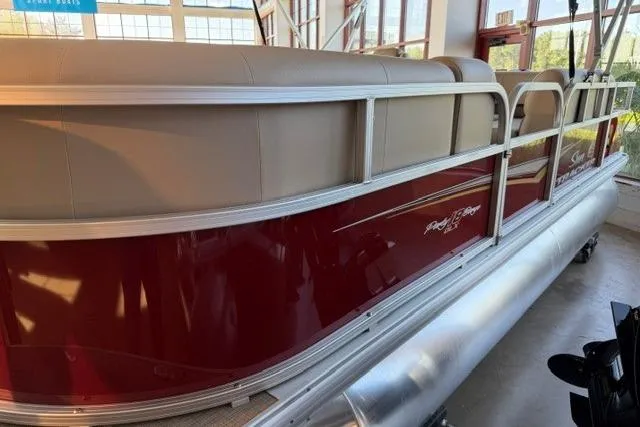 The Image of 2025 Sun Tracker Party Barge 18 DLX pontoon boat with red and beige design in showroom. - 0