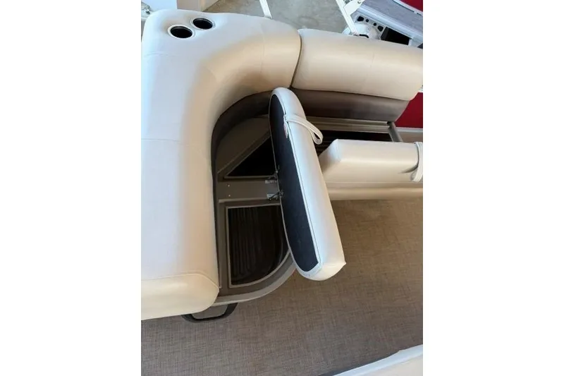Slide: The Image of 2025 Sun Tracker Party Barge 18 DLX interior seating with storage compartment open. - 9