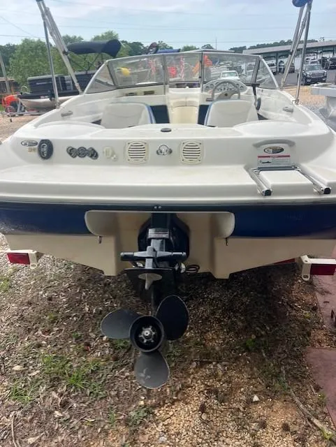 Slide: The Image of 2005 Bayliner 175 Bowrider boat, rear view with outboard motor, parked on gravel. - 3