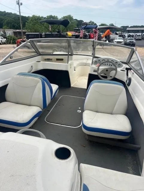 Slide: The Image of 2005 Bayliner 175 Bowrider interior with white and blue seating, steering wheel, and dashboard. - 4