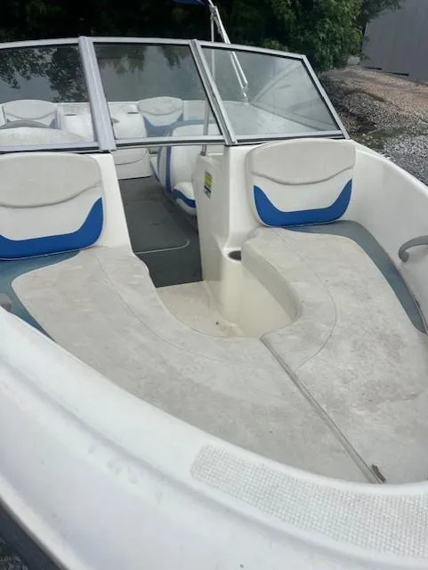 Slide: The Image of 2005 Bayliner 175 Bowrider boat with white and blue interior, docked outdoors. - 7