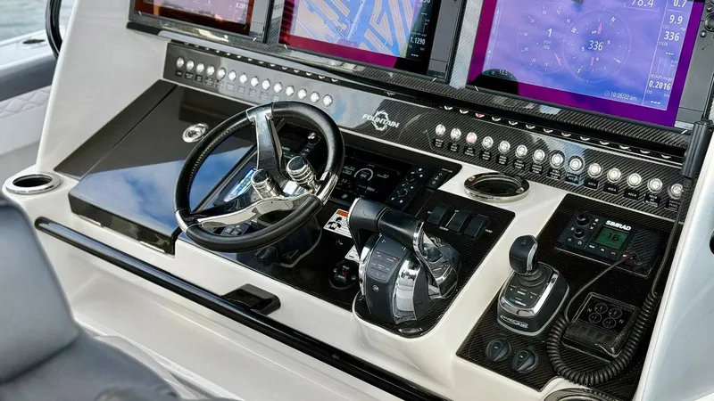 Slide: The Image of Control panel of 2020 Fountain 43NX boat with advanced navigation displays and steering wheel. - 21