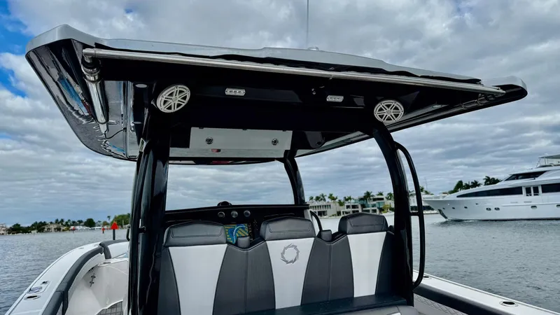 Slide: The Image of 2020 Fountain 43NX boat with sleek seating and canopy on a calm waterway. - 37