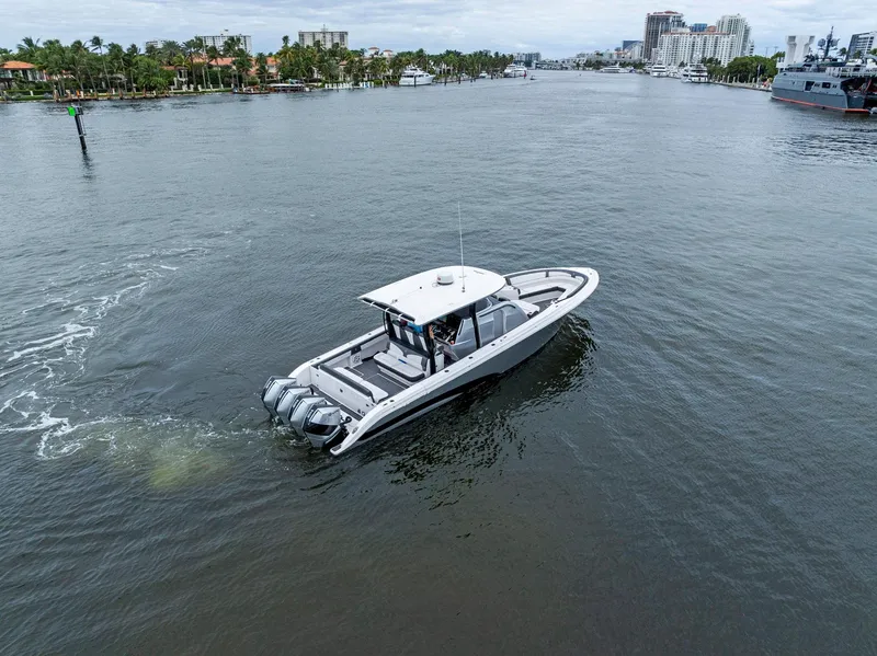 Slide: The Image of Fountain 43NX 2020 boat cruising on a calm waterway with cityscape background. - 42