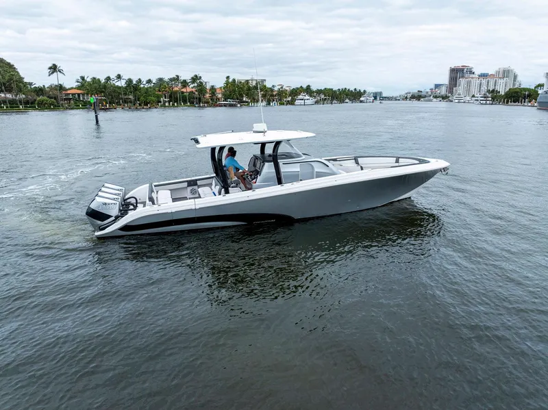 Slide: The Image of 2020 Fountain 43NX boat cruising on a calm waterway with scenic background. - 43