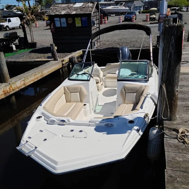 Slide: The Image of 2021 NauticStar 203 DC boat docked at marina, featuring beige seating and sleek design. - 12